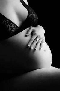 Black and white pregnancy photo of her hand on belly by Phoenix